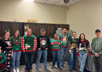 Part of the group of BRN members wearing ugly Christmas sweaters waiting in line to be judged by their sweater for the ugly sweater competition.